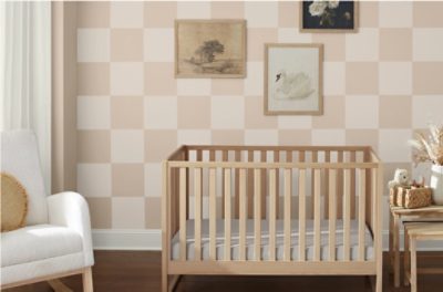 A nursery with a checkerboard wall with Sand Dollar SW 6099 and a warm white.