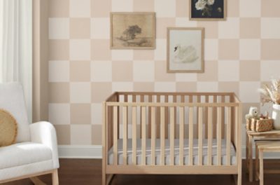 A nursery with a checkerboard wall with Sand Dollar SW 6099 and a warm white.