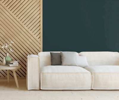 A lowset beige, linen-look sofa in front of a wall painted Cascades SW 7623.