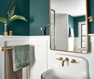 A bathroom with gold fixtures and walls painted Cascades SW 7623 above white wainscoting.