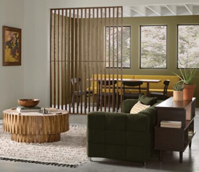 Living room with one wall painted in Palm Leaf SW 7735, with table seating, round coffee table, couch, small table.