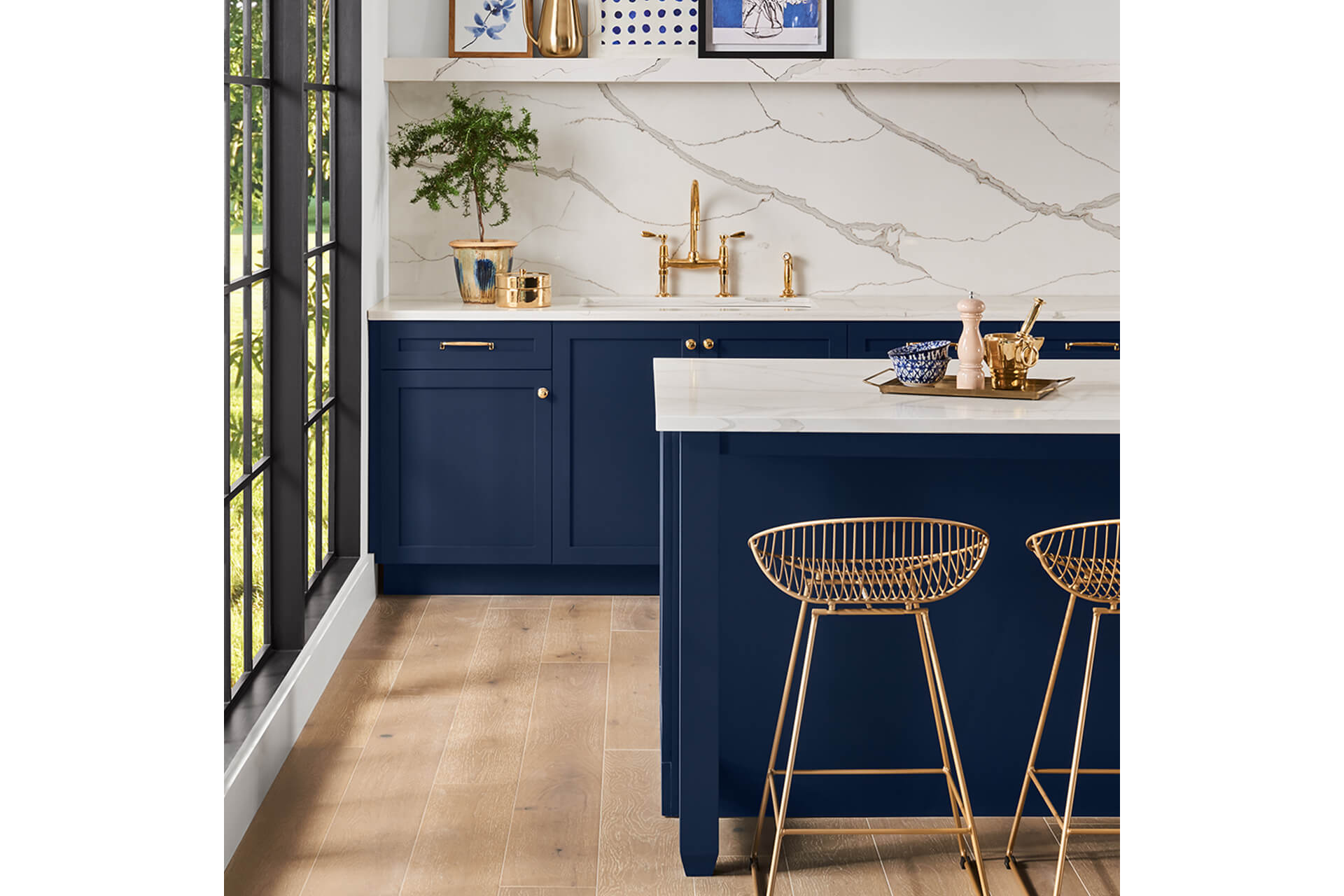 A contemporary kitchen with white countertops, marble backsplash and navy blue cabinets. S-W featured color: SW 6244 Naval.