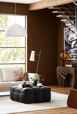 Large living room painted Sherwin-Williams Grounded SW6089 with dark wooden floors alongside a white couch and area rug.