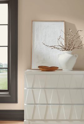 Wall painted Sherwin-Williams Malabar SW9110 including a large window with a black painted frame paired with a large white dresser.