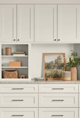 Wooden kitchen cabinets painted Sherwin-Williams Sunbleached SW9585 with black handles.