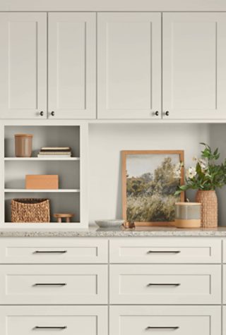 Wooden kitchen cabinets painted Sherwin-Williams Sunbleached SW9585 with black handles.