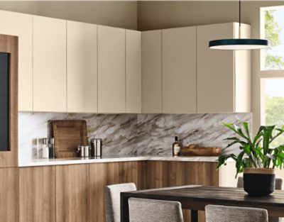 A kitchen with smooth cabinets and walls painted in SW 6150 Universal Khaki, granite backsplash, and a wooden table with chairs around it.