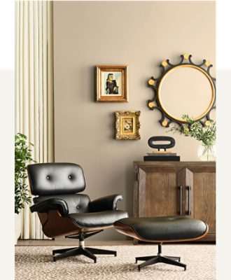 A living space with a black leather recline and ottoman, dark stained dresser with pictures and a circular mirror above and walls painted in Universal Khaki SW 6150.