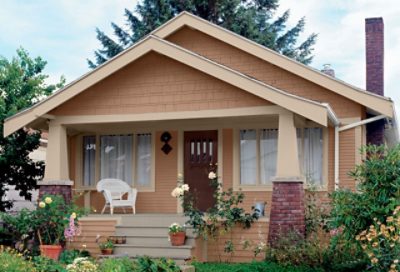 A beige craftsman home with light trim and a chair on the porch. S-W colors featured: SW 2804, SW 0023, SW 2838.