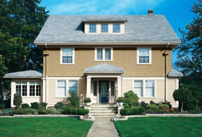 A two-toned beige craftsman home with a blue entry door. S-W colors featured: SW 6119, SW 2842, SW 7012, SW 0048.