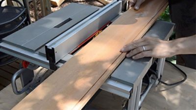 A cutting wood plank table with a saw.