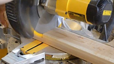 A yellow and black miter saw for wood cutting.