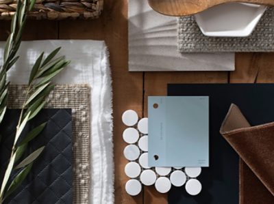 (left) light blue paint chip laid out on a table with different textiles, a fresh herb, and wooden spoon.