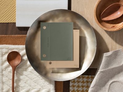 (left) green and brown paint chips inside of a bronze bowl with other warm tones.