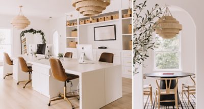 Modern office space with white desks and brown leather chairs, featuring iMac computers, large chandeliers, and built-in shelving.