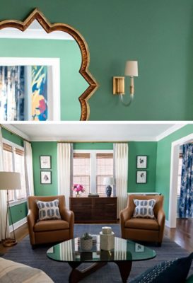 Living room with green walls, tan leather armchairs, a glass coffee table, and a white fireplace with a clover-shaped mirror above it.