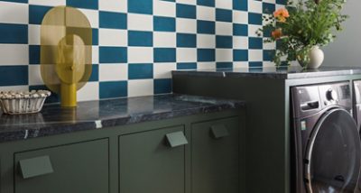 Modern laundry room with Jasper green cabinets, a checkered blue and white wall, and decorative items on the counter.