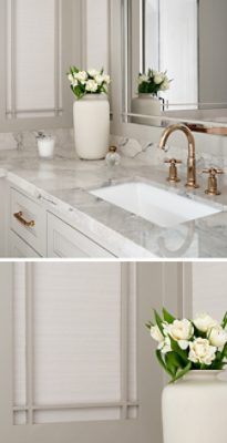Bathroom vanity with marble countertop, gold faucet, and a vase of white flowers with wall panels painted Anew Gray by Sherwin-Williams.