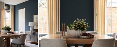 Modern dining room with a wooden table, gray chairs, a floral centerpiece, and large windows with beige curtains against contrasting walls of Grays Harbor by Sherwin-Williams.