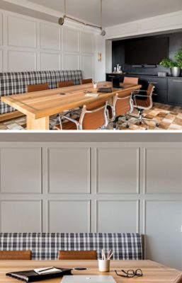 A modern conference room with a large wood table, leather chairs, plaid bench, and mounted TV on a paneled wall.