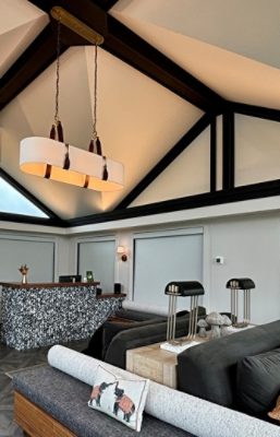 Modern reception area with variegated black and white counters, flower vases, skylights, and decorative elements.