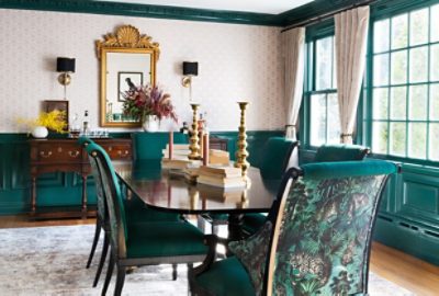 Image of dining room with dark green accents and patterned wallpaper.