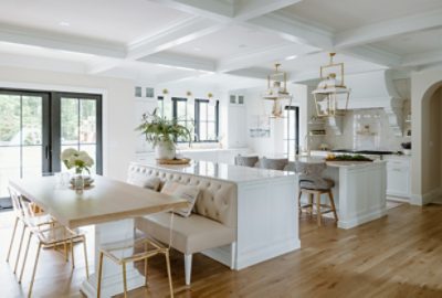 Very bright white and neutral kitchen with wooden floors and many windows.
