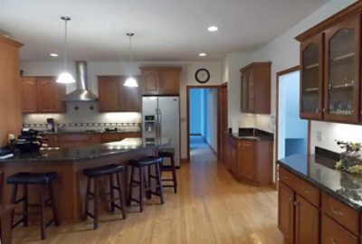 before photo of kitchen with dark cabinets and furniture.