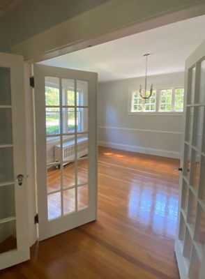 empty room with wood flooring and double window doors.