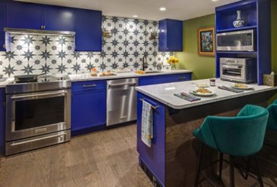 Image of bright blue cabinets and stainless steel appliances in a modern kitchen.