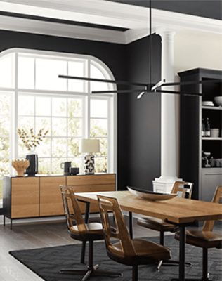 Dining room with large window, wooden furniture and black/white walls.