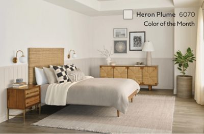 A bedroom with wainscoting on the bottom half that is painted Heron Plume SW 6070.