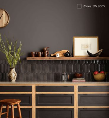 A countertop with dark brown tiles under one shelf with walls painted Clove SW 9605.