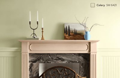 A wood fireplace stained a light orange-brown with walls painted Celery SW 6421.