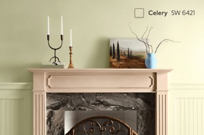 A wood fireplace stained a light orange-brown with walls painted Celery SW 6421.