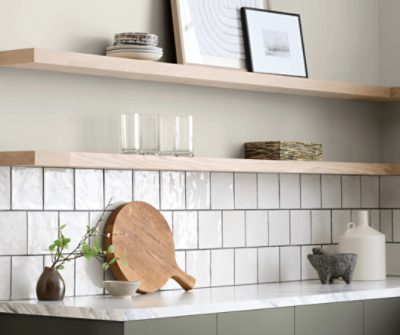 A kitchen with the space above the square tiled backsplash painted Drift of Mist SW 9166 and lower cabinets painted Thunderous SW 6201.