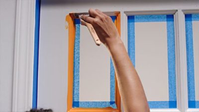 Taping the panes of a glass door in a home office.