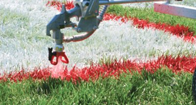 A field being sprayed with red paint.