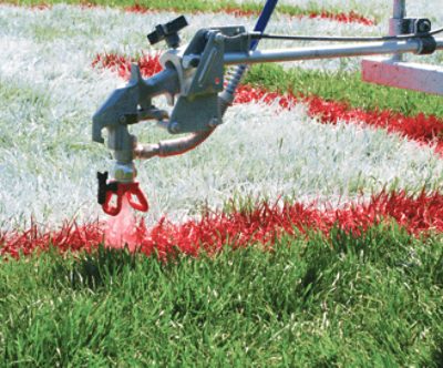 A field being sprayed with red paint.