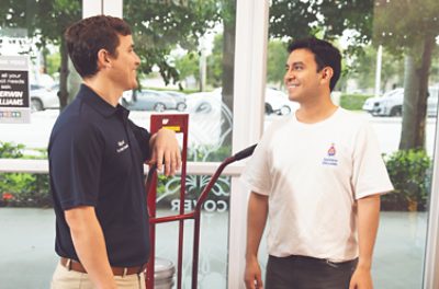 A store employee and a contractor talking inside a Sherwin-Williams store.