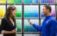 A Sherwin-Williams employee helping a customer choose a color in front of a color wall.