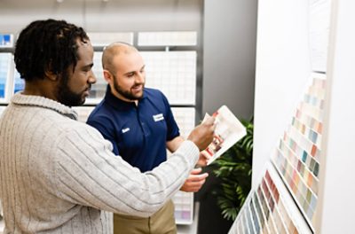 A customer and Sherwin-Williams employee looking at paint chips and brochures. 