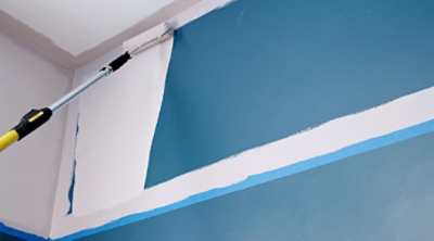 Painting a wall blue using an extended roller.