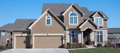 A beige painted house with windows.