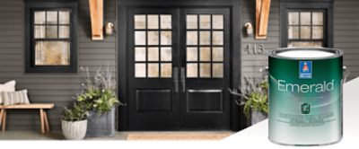 The exterior of a home with black doors with square glass windows and siding painted in dark gray. Product featured Emerald Urethane Trim Enamel.