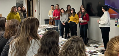 Conference room with tables full of mood boards amidst a gathering of Account Executives and color trend experts.