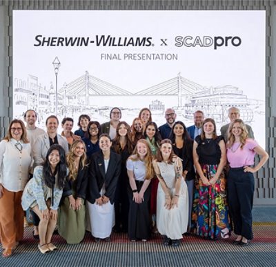 Group of people standing and smiling in front of a backdrop with "SHERWIN-WILLIAMS x SCADpro FINAL PRESENTATION" text.