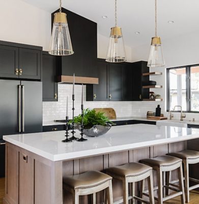Modern kitchen with black cabinets, white marble island, and pendant lighting.