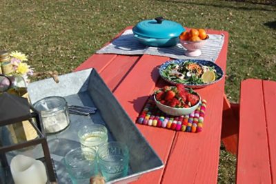 A picnic table painted a red-orange Daring SW 6879.