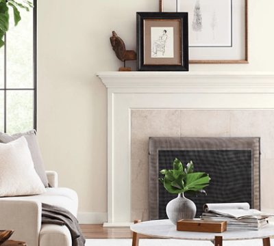 Neutral living room with fireplace, couch, coffee table with minimal decor.